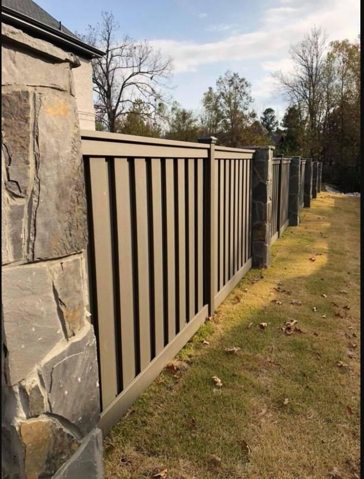 Tan composite privacy fence installed between stone columns
