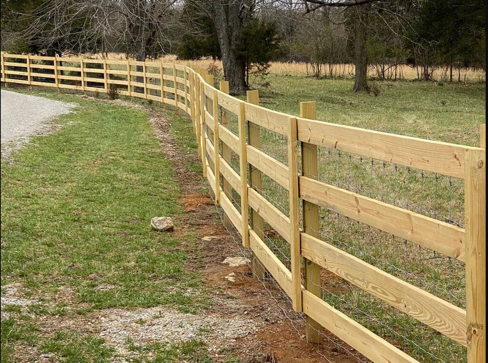 Completed wood board farm fence following a rural drive
