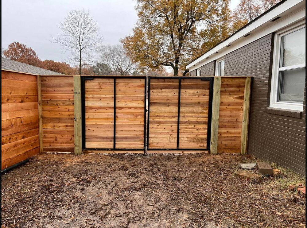 Completed framed wood privacy fence with black posts